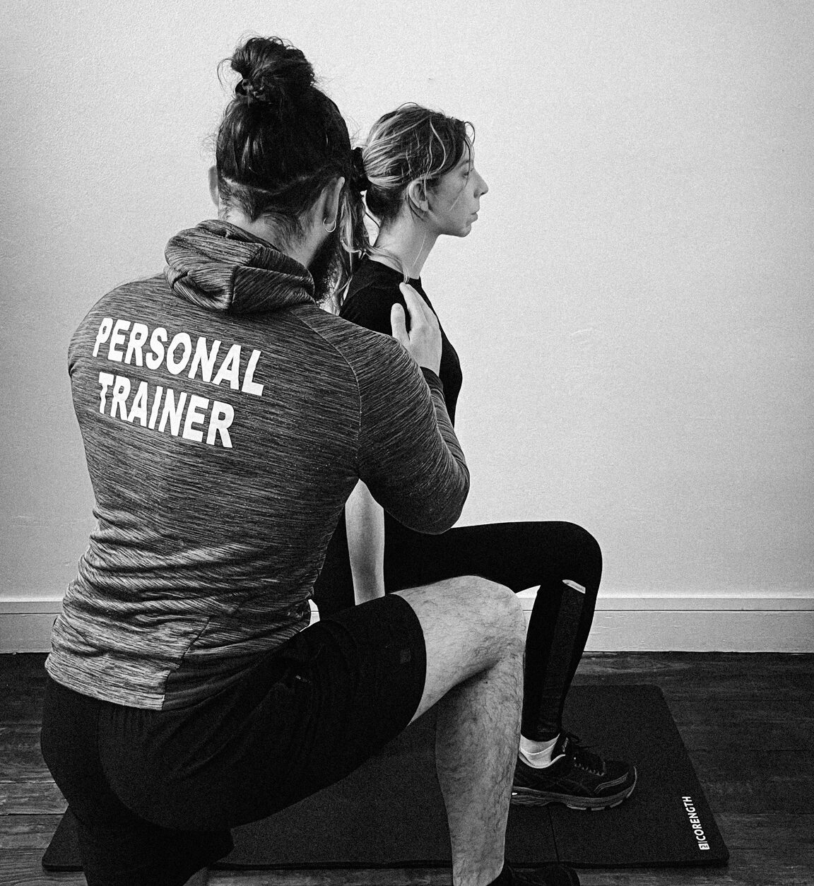 Emeric Solon, en tenue Personal Trainer, guidant une cliente pendant une séance d'entraînement personnalisé