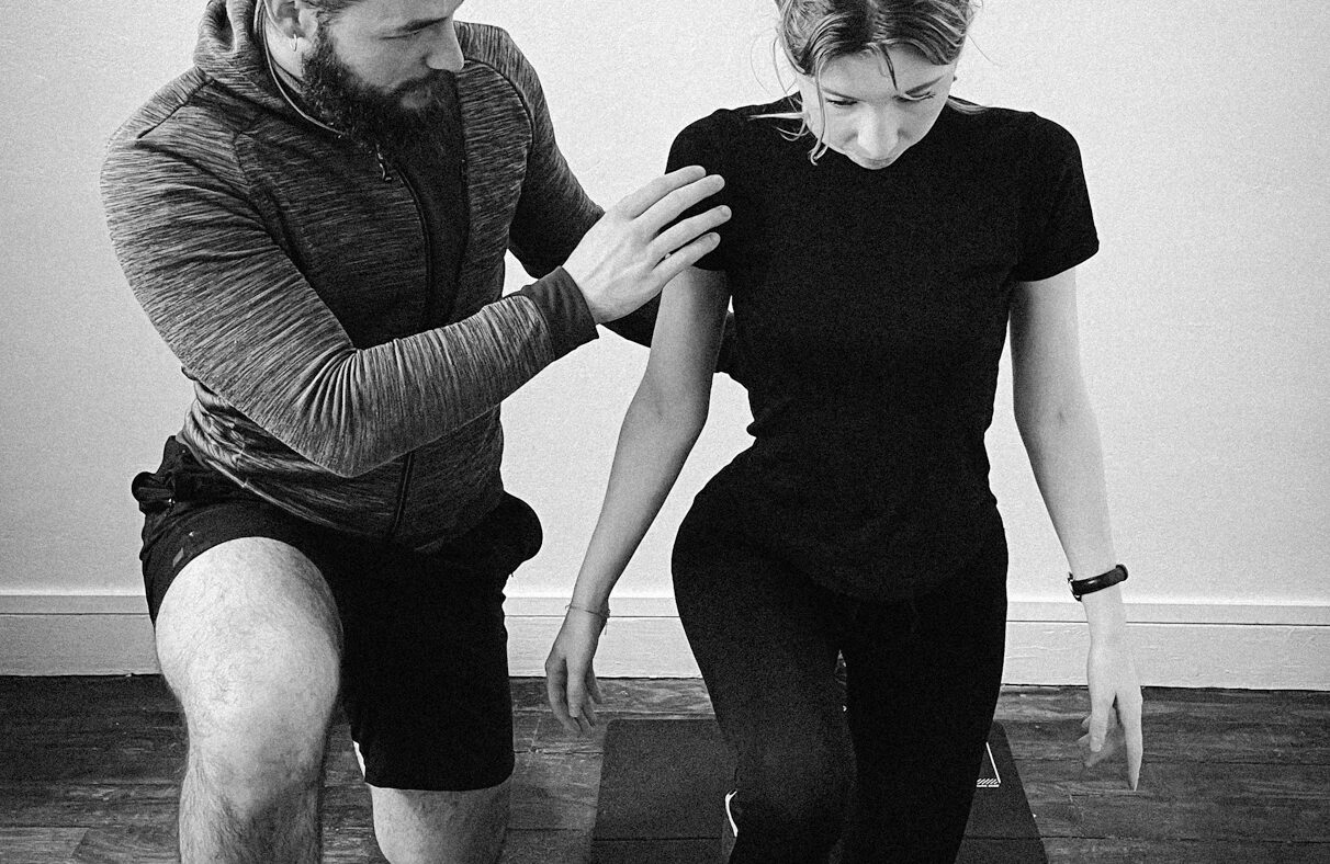 Emeric Solon corrigeant la posture d'une cliente pendant un exercice de gainage